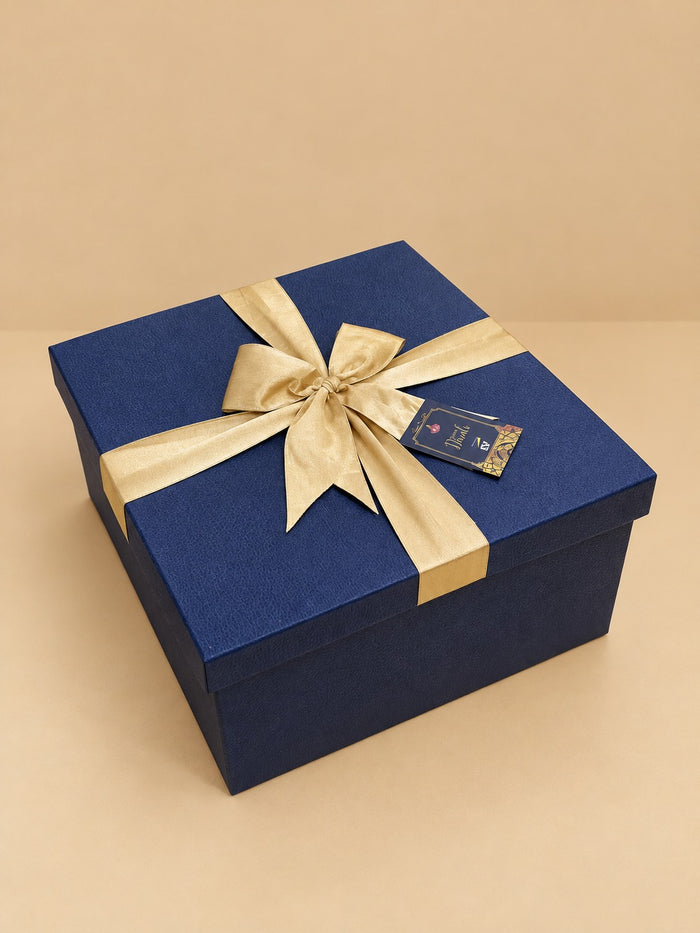 Textured navy blue Diwali gift box with gold satin bow and tag for corporate gifting, by Demould Delhi